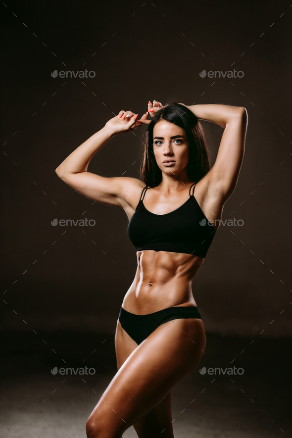 sexy fitness woman posing in underwear indoors on black background