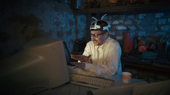 Video conference in group virtual chat. Computer nerd in an old garage and a cup on the table alt