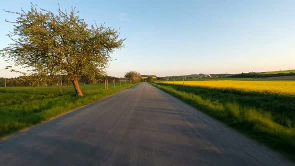 Car driving in spring time in rural countryside alt