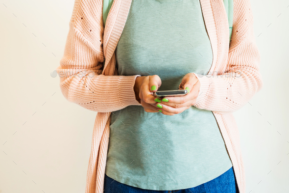 Woman in pastel clothes using mobile phone