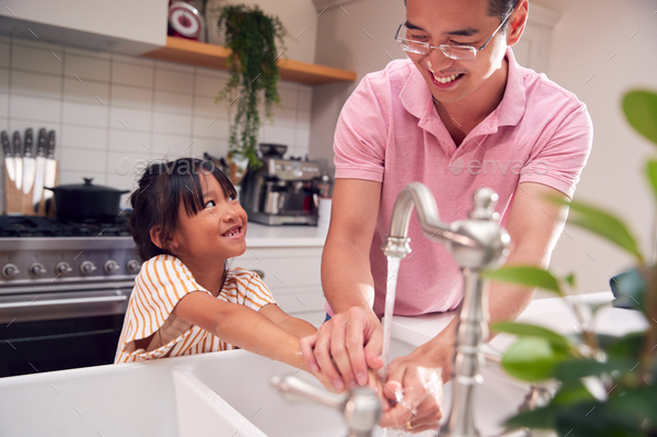 Asian Father Helping Daughter To Wash Hands With Soap At Home To Stop Infection In Health Pandemic