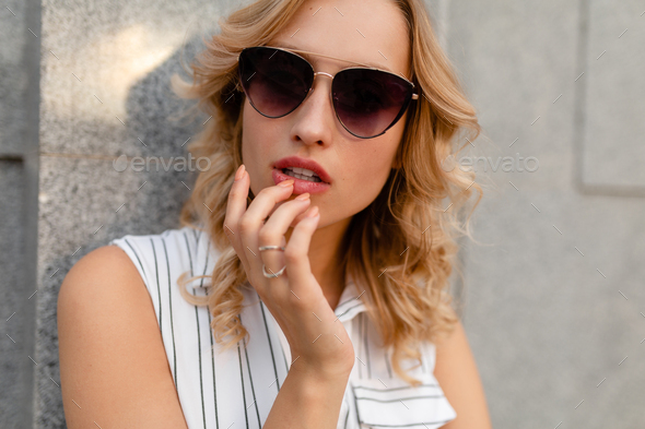 close-up portrait of young attractive stylish blonde woman in city street  in summer fashion style Stock Photo by marymandarinka