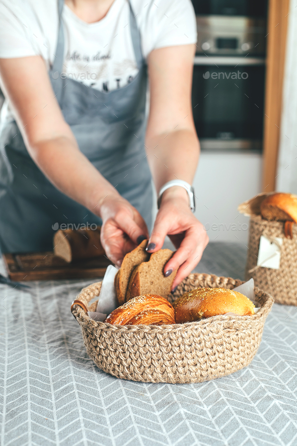 Woman in apron cuts homemade gluten-free bread. Home bakery, home cooking