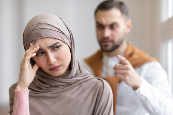 Aggressive Muslim Husband Shouting At Depressed Wife Standing At Home