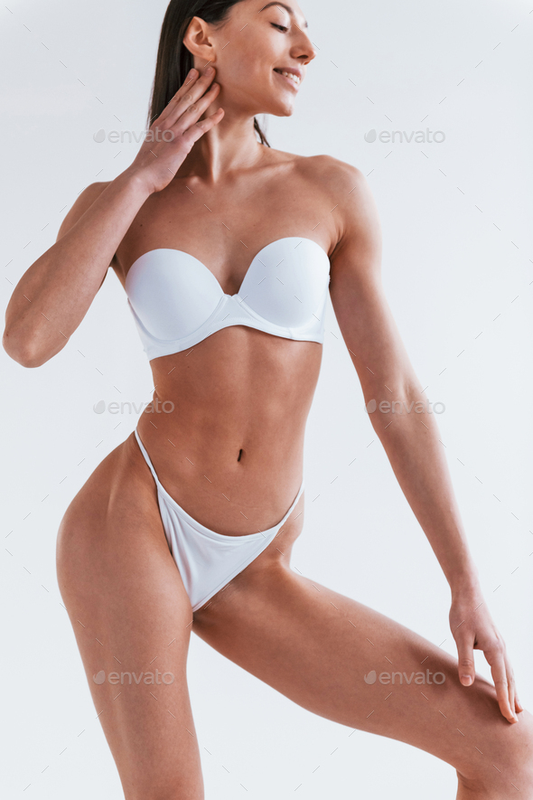 Young woman in underwear and with nice body shape is posing in the studio  against white background Stock Photo by mstandret