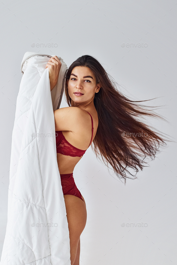 Young woman in underwear and with nice body shape is posing in the studio  against white background Stock Photo by mstandret