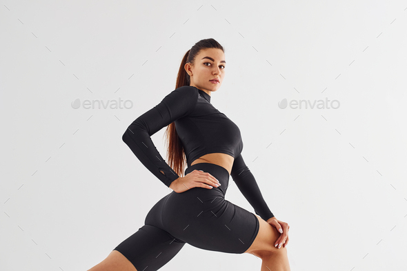 Twerk dancing. Sportive woman in black clothes in the studio against white  background Stock Photo by mstandret