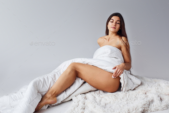 Woman in underwear sits in the studio against white background Stock Photo  by mstandret
