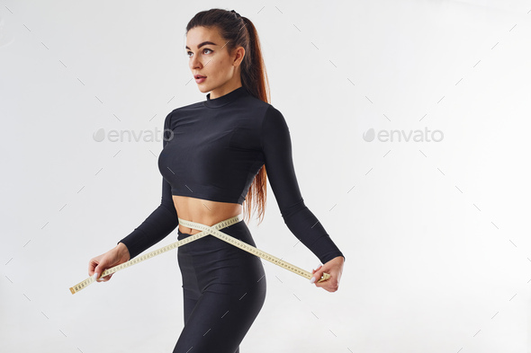 Women's waist with a measuring tape on white background, Stock image