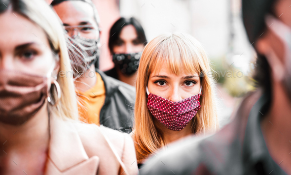Urban crowd of citizens walking on city street covered by face mask