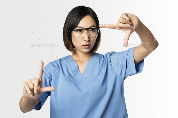 Medical worker in medical uniform doing a zoom gesture on invisible screen