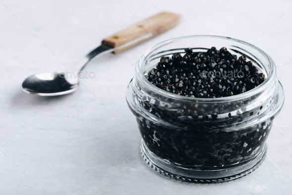 Download Black Caviar In Glass Jar On White Stone Background Luxurious Delicacy Appetizer Stock Photo By Nblxer