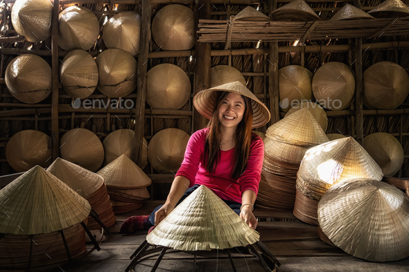 Asian traveler female craftsman making the traditional vietnam hat in the old traditional house