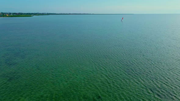 Drone Flying Over the Sea Towards the Windsurfer alt