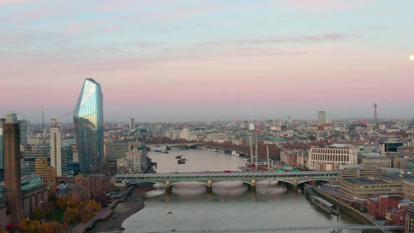 Dolly forward aerial of millennium and Blackfriars bridge over Thames river early morning sunrise alt