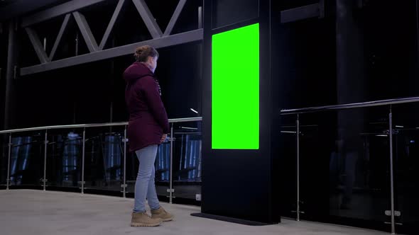 Green Screen Concept - Woman Looking at Blank Green Display Kiosk at Exhibition