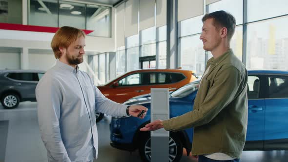Dealership Manager Hands Over the Keys to a New Car alt
