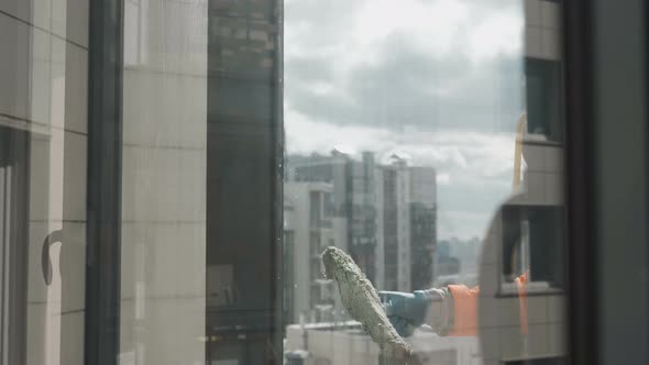 Smiling Industrial Climber Washes Windows High Altitude Outside Against Background Sunlight alt