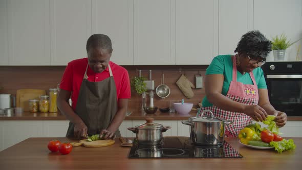 Senior African Couple Cooking Together in Kitchen alt
