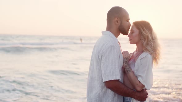 Young Beautiful Couple in Love Standing and Hugging on Beach By the Sea