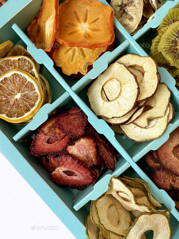 Box with dried fruits chips isolated on white, top view. Stock Photo by Vladdeep