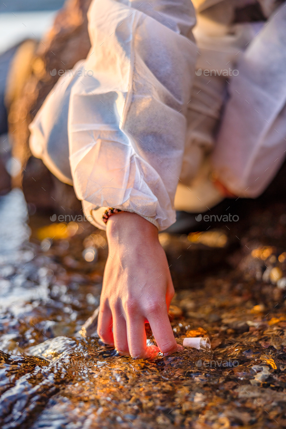 Close-up of scientist collecting water sample at seashore - Stock Photo - Images