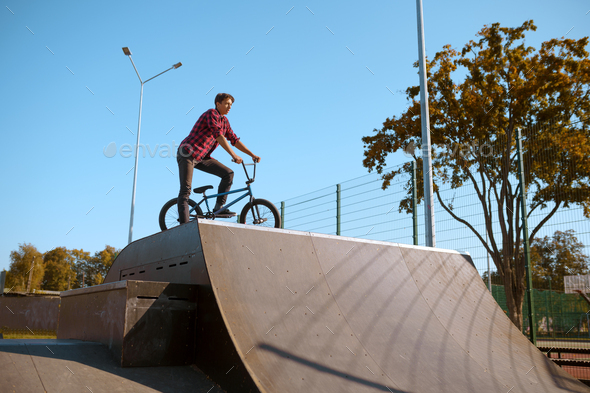 Bmx biker doing trick,teenager in skatepark