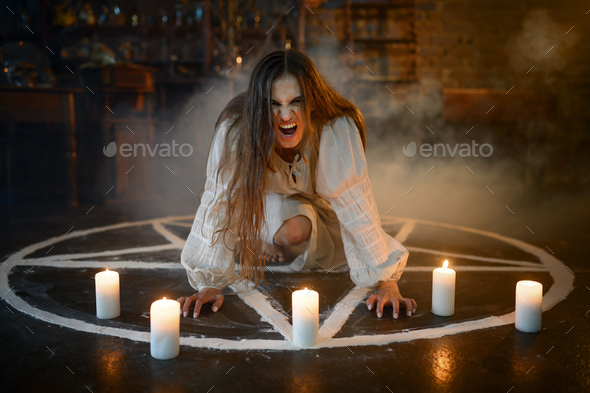 Crazy woman sitting in magic circle with candles