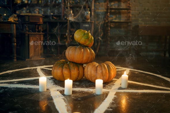 Magic circle with pumpkins and burning candles