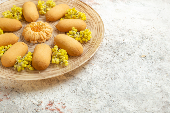 right sideline shot of a plate of cookies with bright yellow flowers on a white marble ground