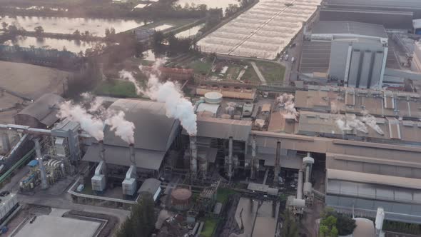 Aerial view Drone shot of flying around toxic chimneys tubing. Air Pollutants, Industrial zone.