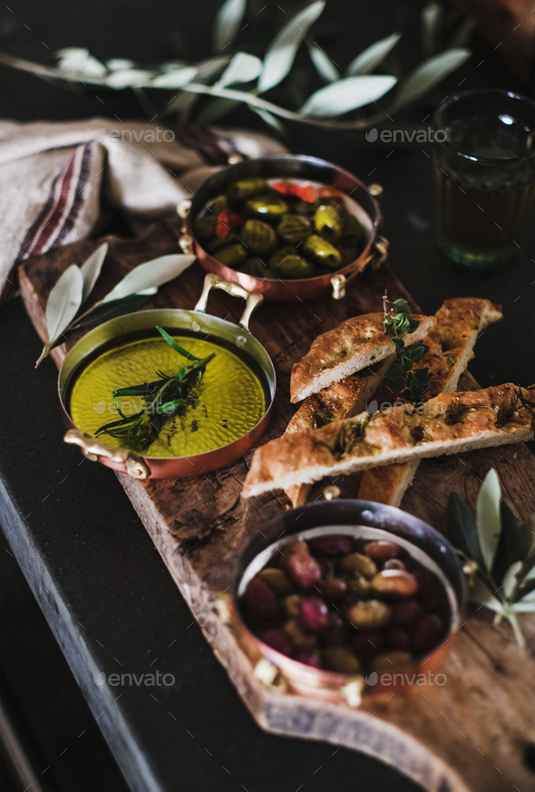 Pickled Greek olives, olive oil and herbed focaccia slices - Stock Photo - Images