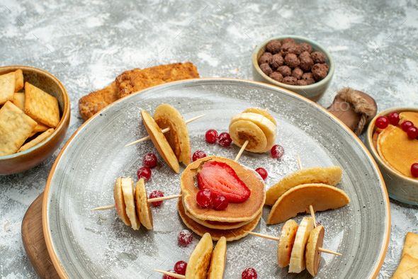 Close up view of delicious pancakes biscuits and cakes for breakfast on light background
