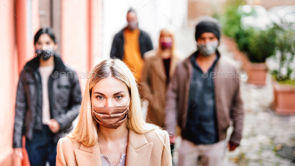 Urban crowd of young people walking on city street covered by face mask