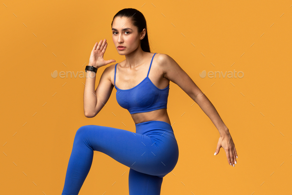 Young Woman Running And Exercising Isolated On Orange Background
