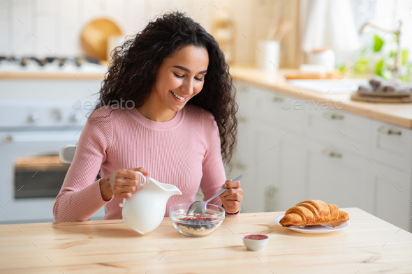 Portrait of Happy Indian teenage girl in kitchen holding cooking