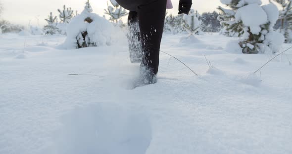 Woman Walking in Deep Snow on Sunny Winter Day Close Up Slow Motion alt