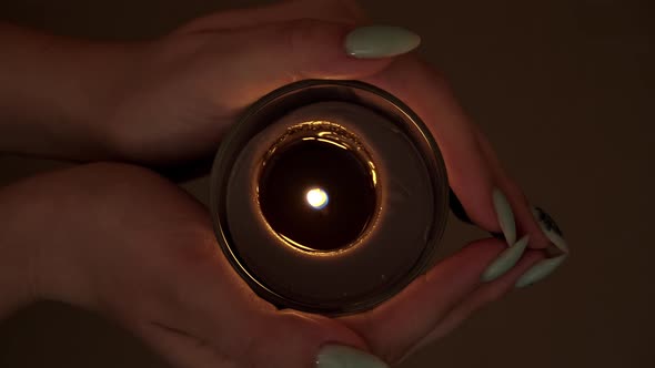 Candle Burns Atmospherically in the Hands of a Girl with a Beautiful Manicure alt