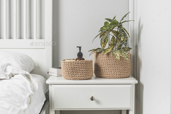 Scandinavian interior in white colors. Home plant in jute basket. Lifestyle authentic concept.