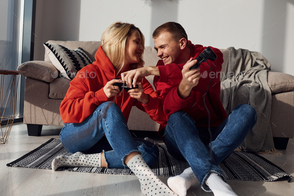 Young lovely couple together at home playing video games at weekend and holidays time together