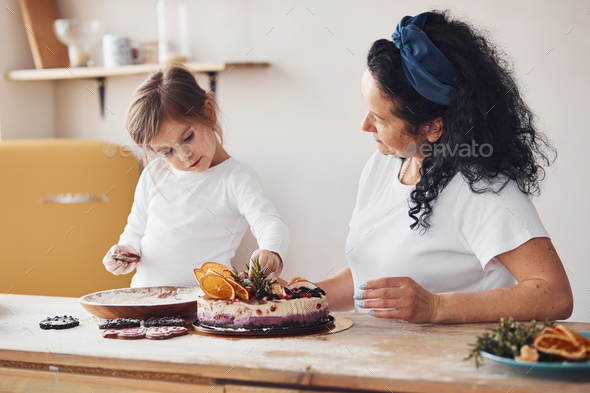 Senior woman with her granddaughter preparing dietical cake on kitchen