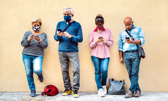 Senior people using mobile smart phone with face mask covered
