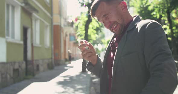 Unhealthy Man Sneezes and Sprays Nose and Into Camera with Nasal Spray on Street alt