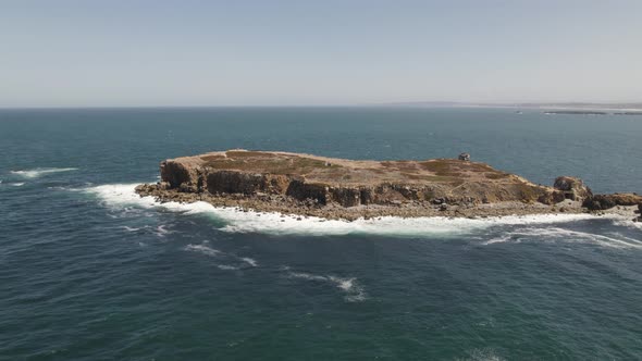 Iconic rocky peninsula in Peniche, Portugal - Papôa scenic spot; drone riser