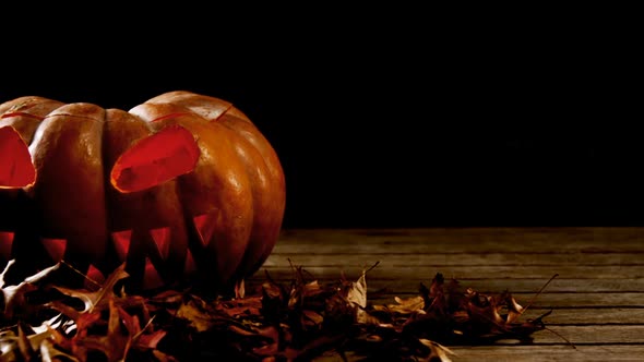 Halloween pumpkin with maple leaf on a wooden table 4k alt