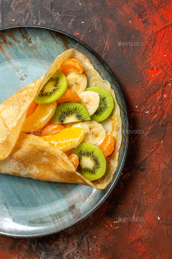 https://s3.envato.com/files/322010173/Vertical%20view%20of%20citrus%20fruits%20in%20(delicious%20crepes)on%20a%20blue%20plate%20on%20mixed%20color%20background.jpg