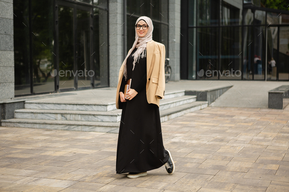 modern stylish muslim woman in hijab in city street