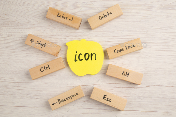 top view keyboard icons on wood blocks icon written on yellow sticky note on table