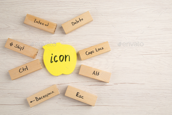 top view keyboard icons on wood blocks icon written on yellow sticky note