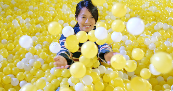 Woman play inside the ball pit